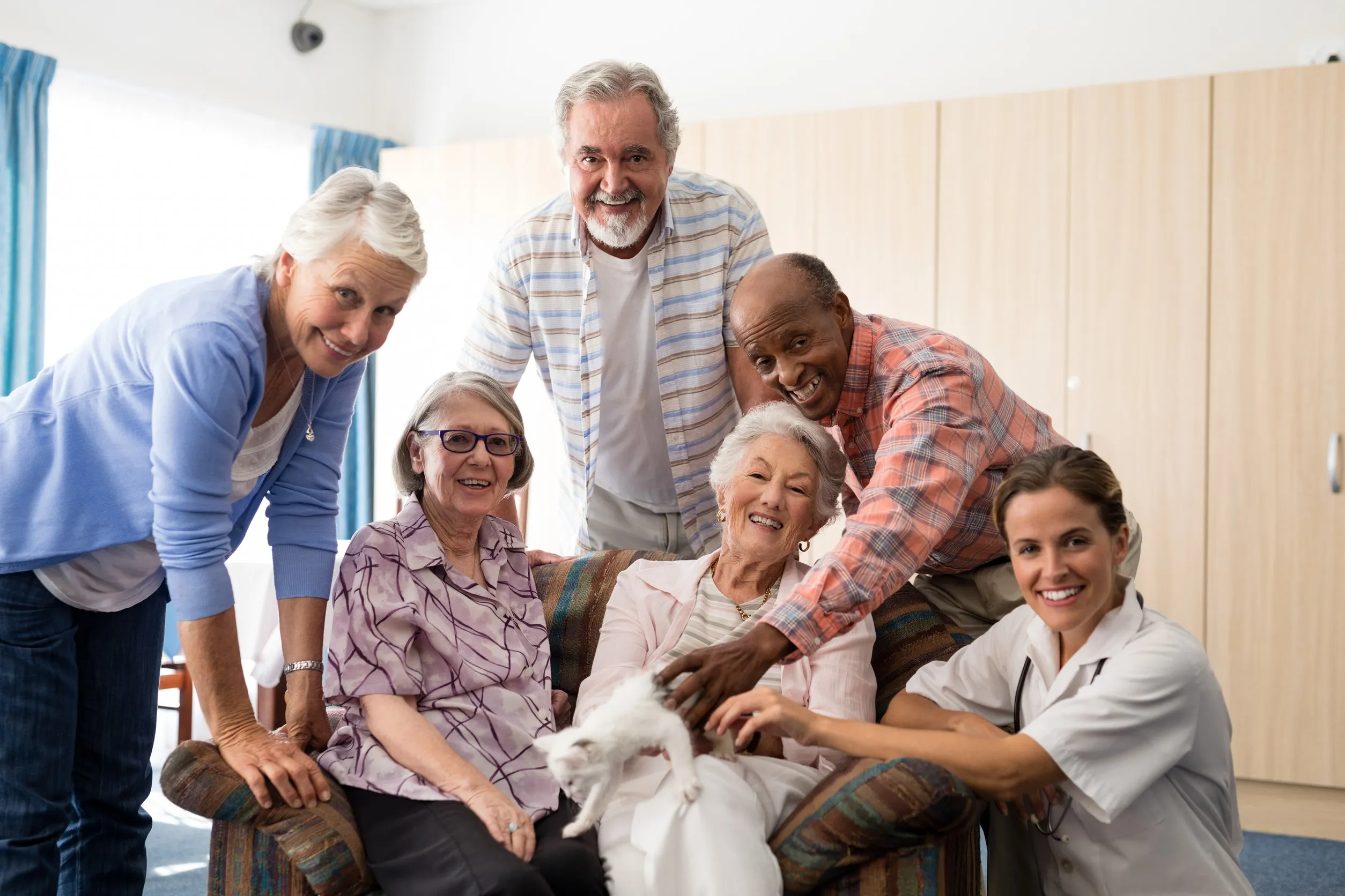 Portrait of female doctor and senior people with kitten at nursing home Portrait of female doctor and senior people with kitten at nursing home